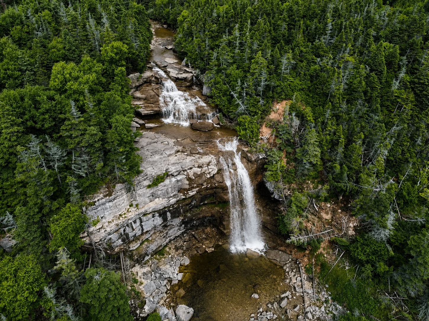 Aerial view of a hidden waterfall plunging into the ocean on the Newfoundland coast